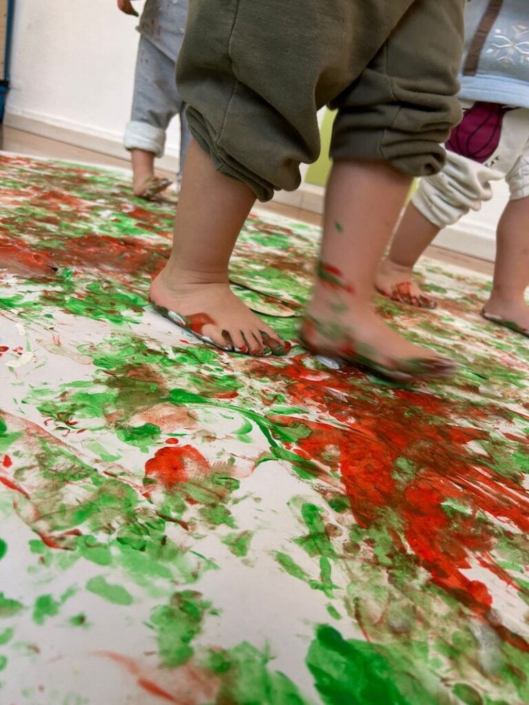 Bambini impegnati in attività grafico-manipolative presso l'asilo nido Arlecchino